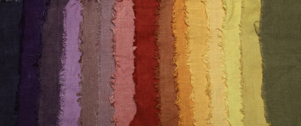 rainbow of naturally dyed linen cloth from purple, pink orange, yellow to green. 